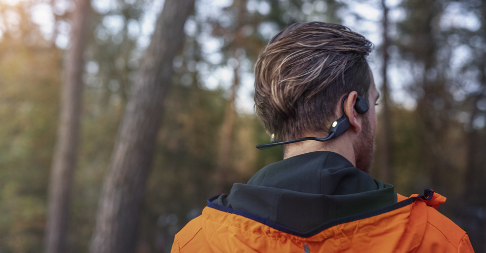 Man wearing wireless headphones during an outdoor workout.